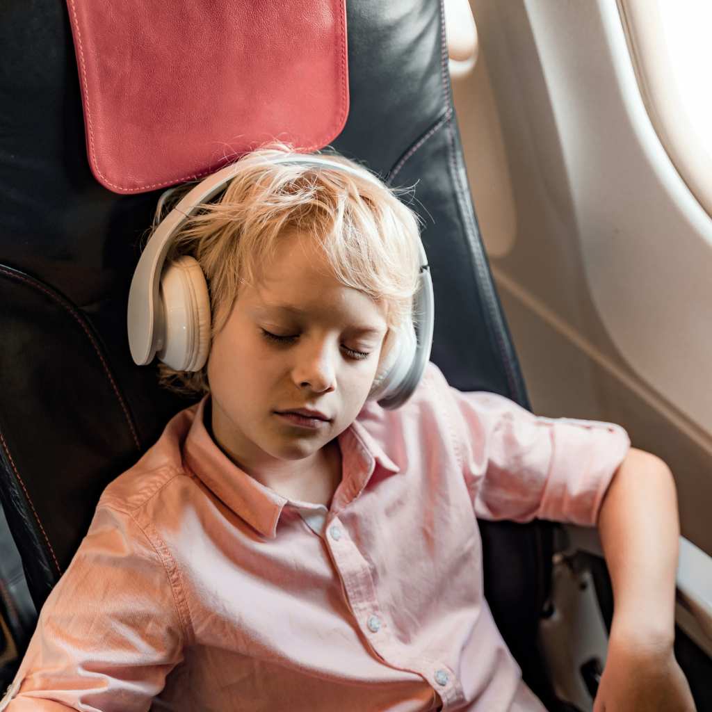 A child using headphones on an airplane to help create a quieter, more comfortable space