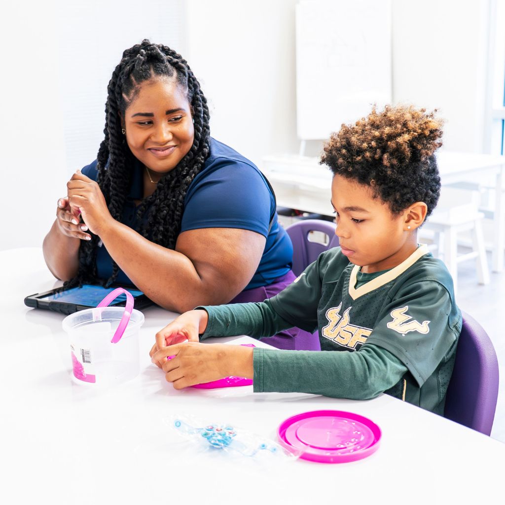 ABA therapist supporting a child during an individualized ABA therapy session using hands-on activities to encourage learning, fine motor skills, and engagement.