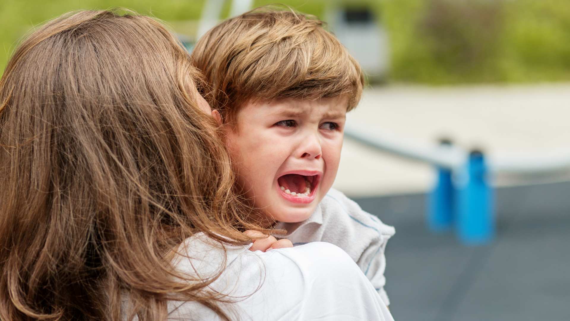 Adult carrying an emotional child who is having a hard time