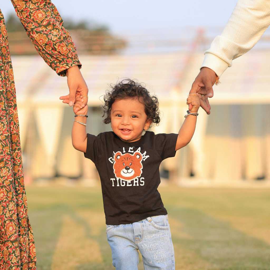 12-month-old walking with parents, observing communication and social cues for autism signs