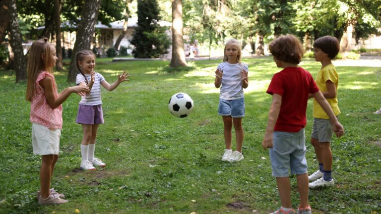 Children playing soccer on a grassy field, representing athletes with autism and the benefits of autism in sports