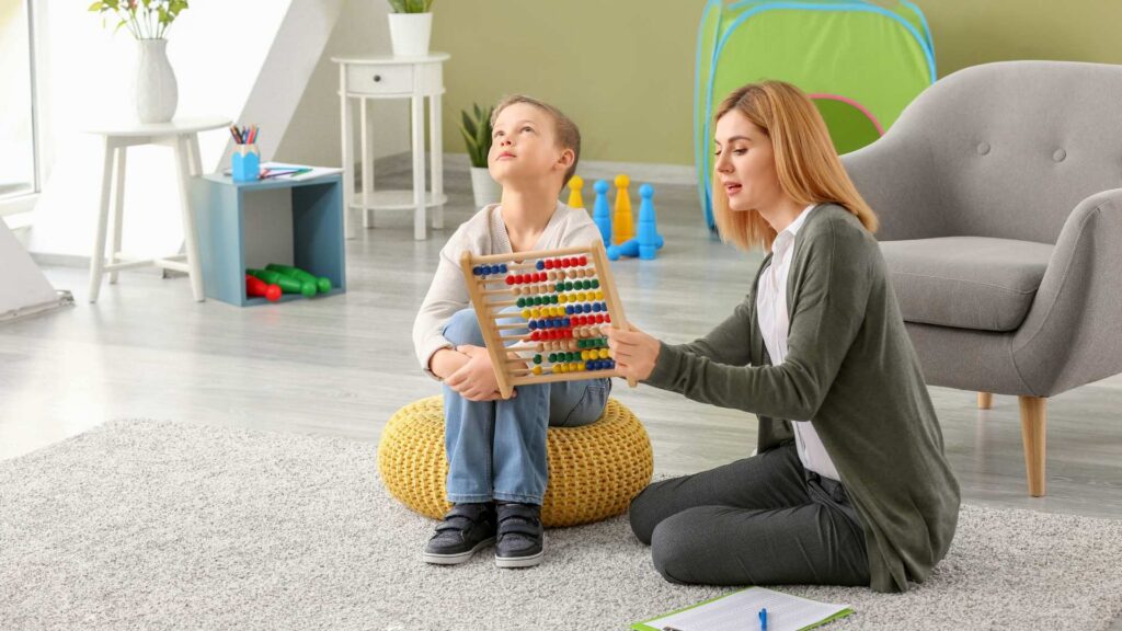 Clinician guiding a child with an abacus during an autism evaluation activity