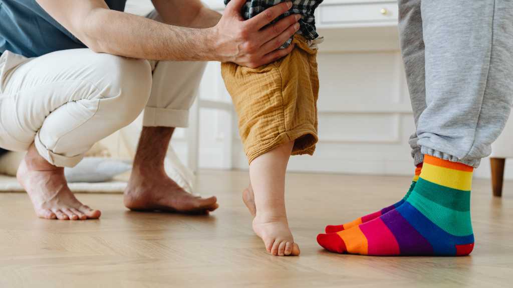 Baby learning to walk with support, observing developmental milestones and autism signs