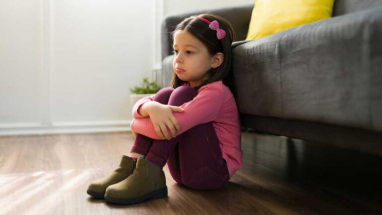 3-year-old girl sitting alone, possible signs of autism in a 3-year-old and social withdrawal