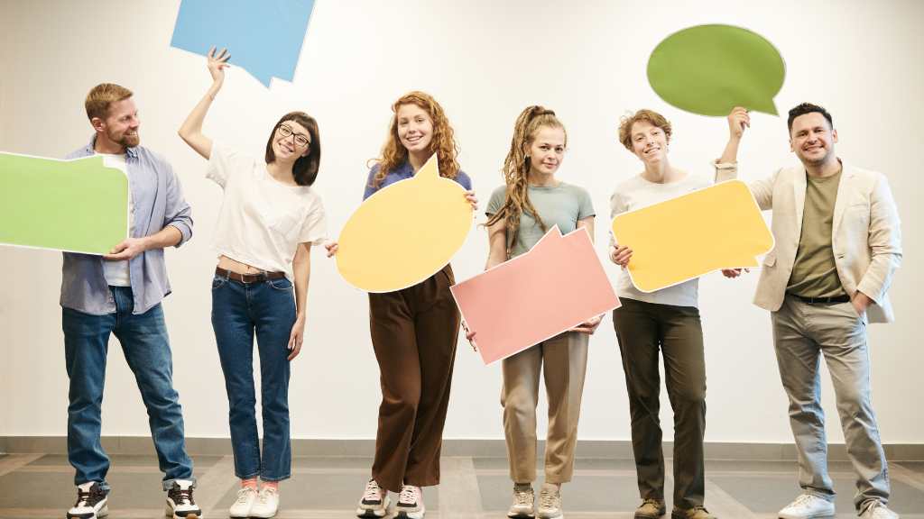 Diverse group of people standing with speech bubbles, symbolizing the urgent need for autism self-advocacy and collective voices