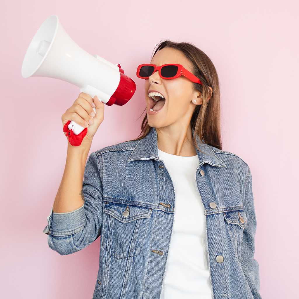 Young woman holding a megaphone and speaking out, representing what self-advocacy really means in autism self-advocacy