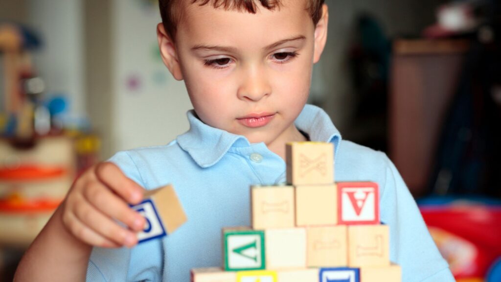 Young boy playing with blocks indoors