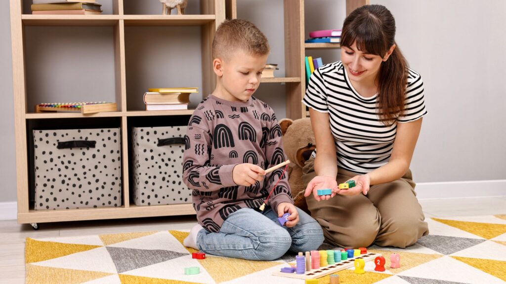 Young child participating in a play-based ABA therapy session with a therapist using colorful educational toys to support early learning and developmental skills.