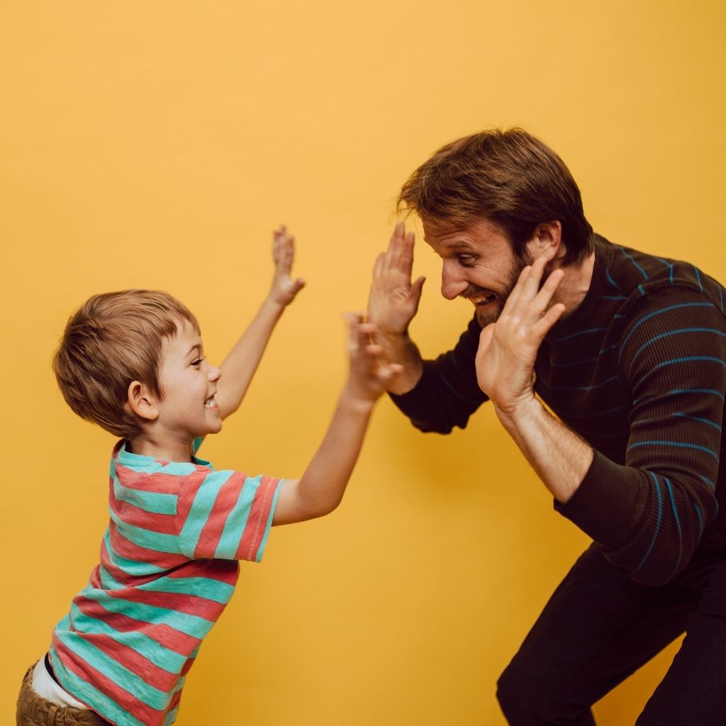 Parent and young child sharing a high-five during an everyday interaction applying aba strategies for parents
