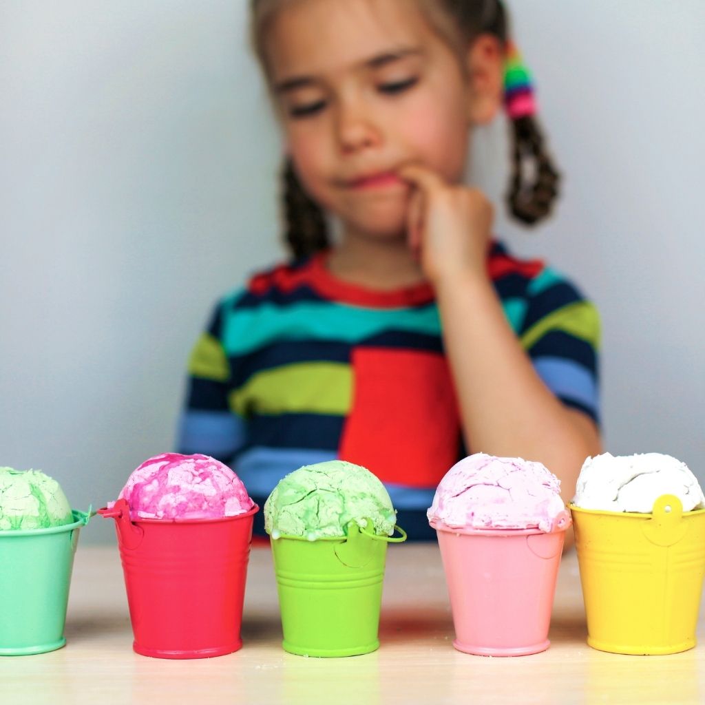 Child choosing between two pieces of fruit during an everyday routine
