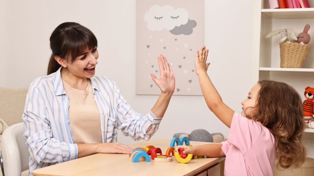Child receiving positive reinforcement during an ABA learning activity