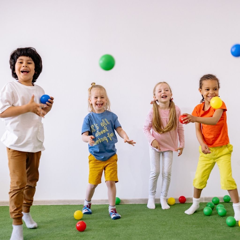 Preschool-aged children playing together with colorful balls