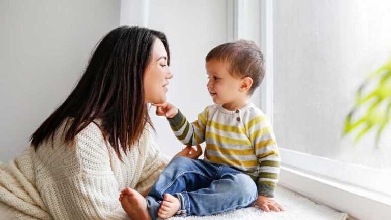 Toddler communicating with caregiver during ABA therapy for speech delay