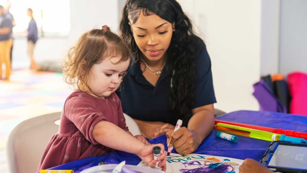 How early should ABA therapy start ABA therapist helping a toddler with an art activity