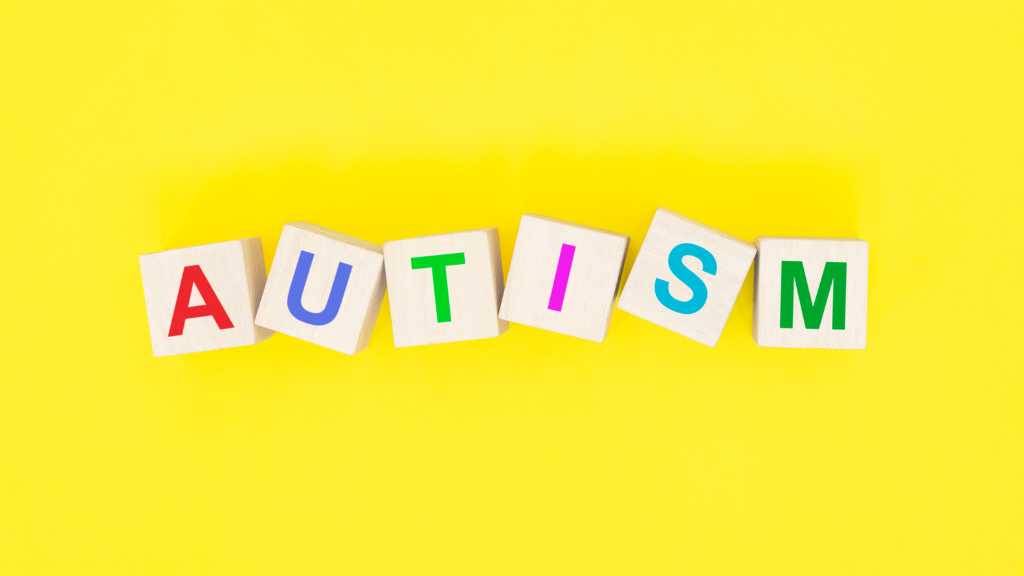 Explaining autism letter blocks on yellow background
