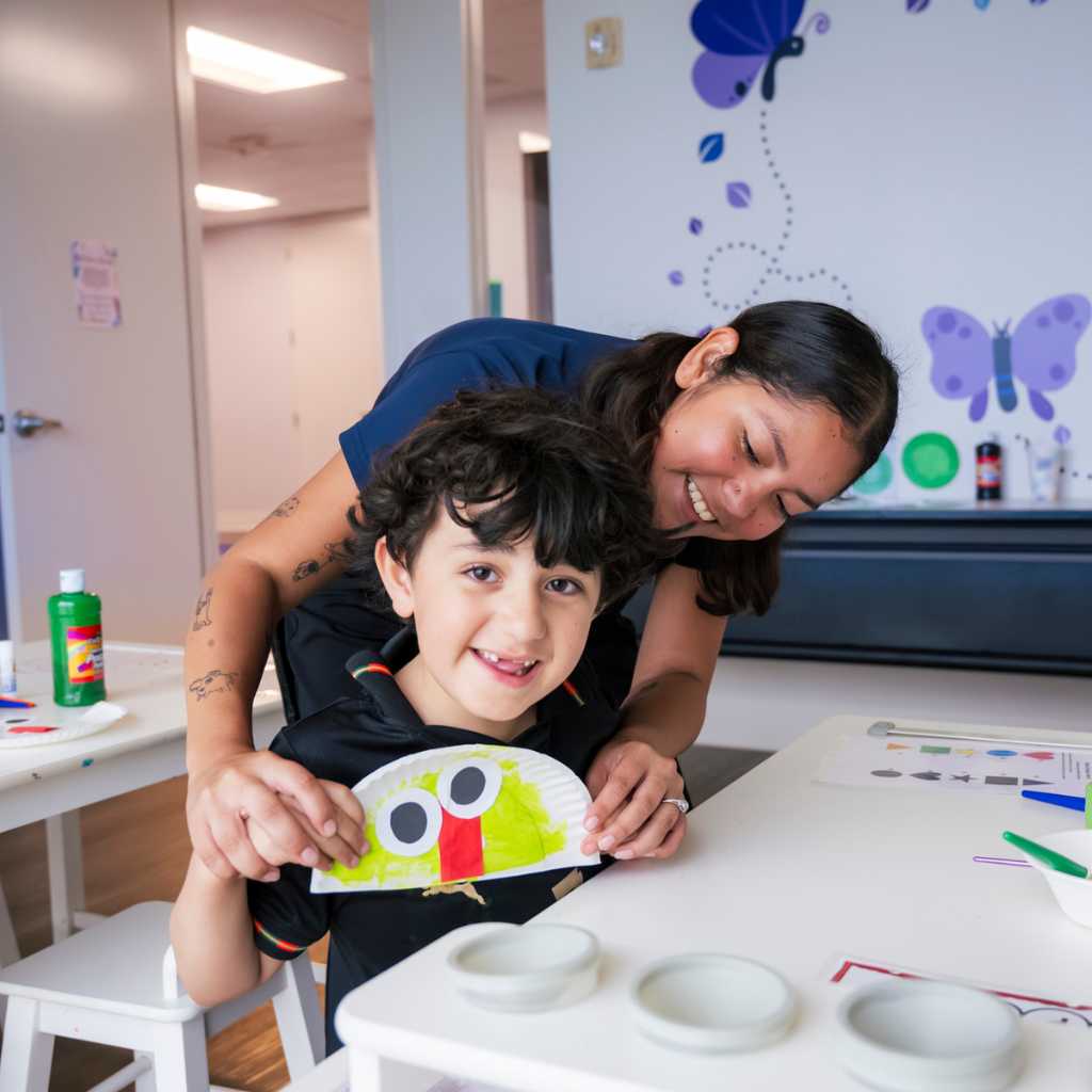 Autism behavior specialist helping child with therapy activity