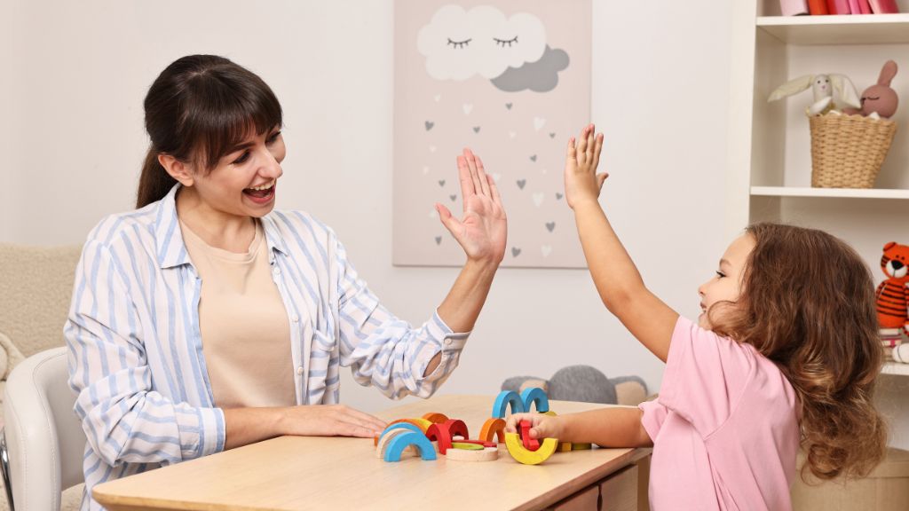 Adult and child high-five during a positive learning activity