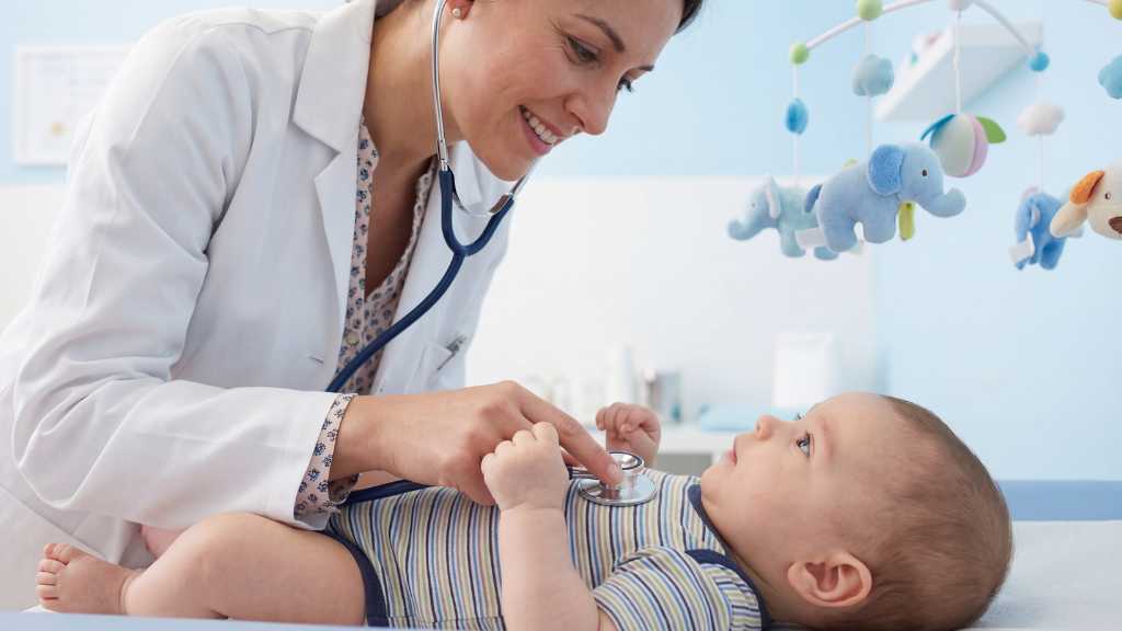 Pediatrician examining baby for developmental delay during checkup
