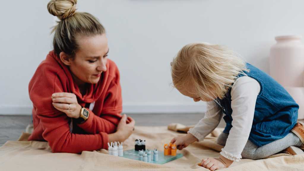 Parent observing toddler during play, diagnosing autism through developmental interaction