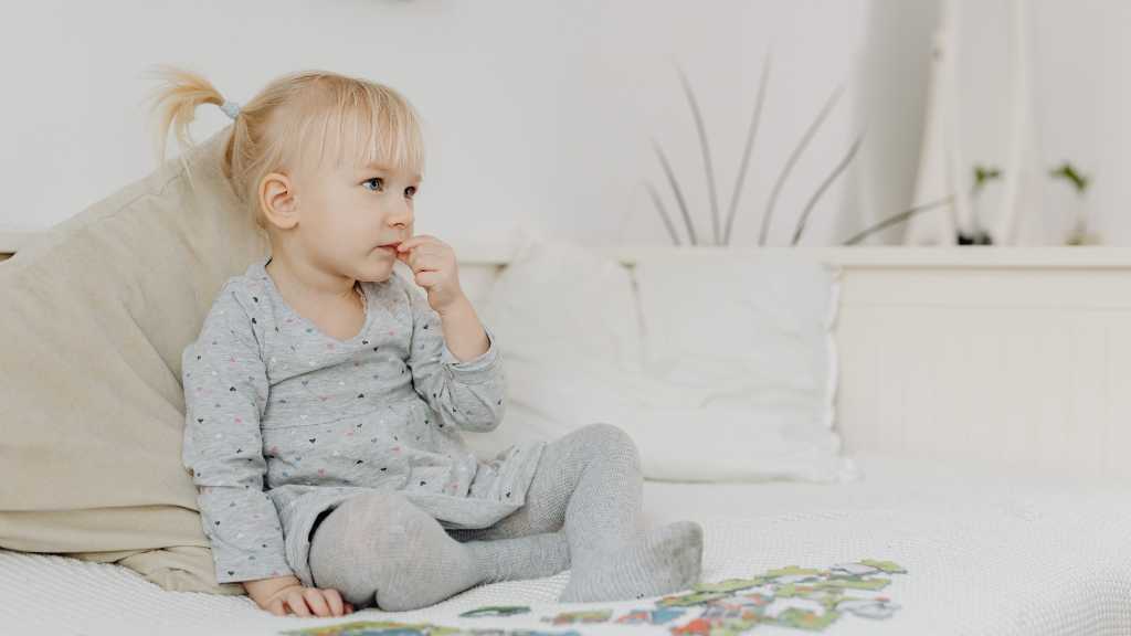 Toddler sitting quietly, possible signs of autism in a 2-year-old and delayed response behaviors