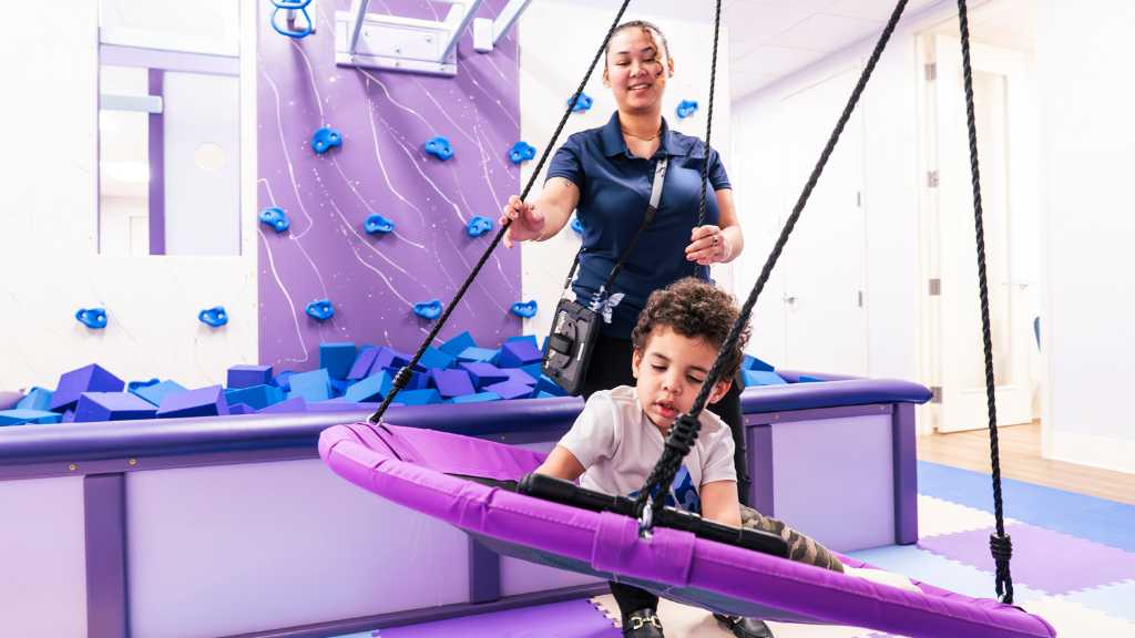 Child participating in early autism therapy with sensory play equipment