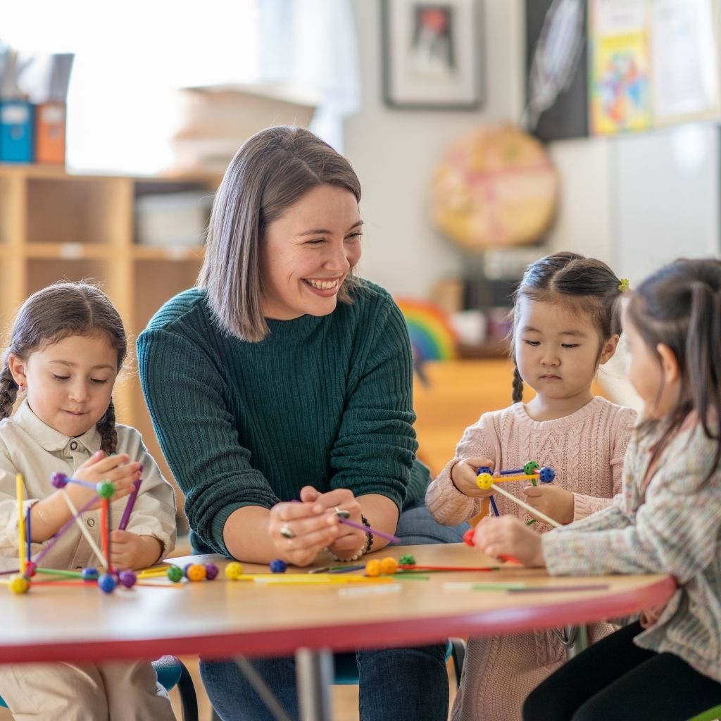 Teacher participating in a classroom activity with young children