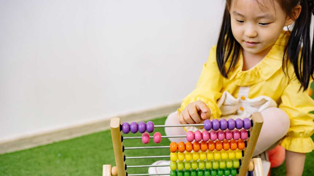 Child focusing on an abacus activity demonstrating focused attention in autism