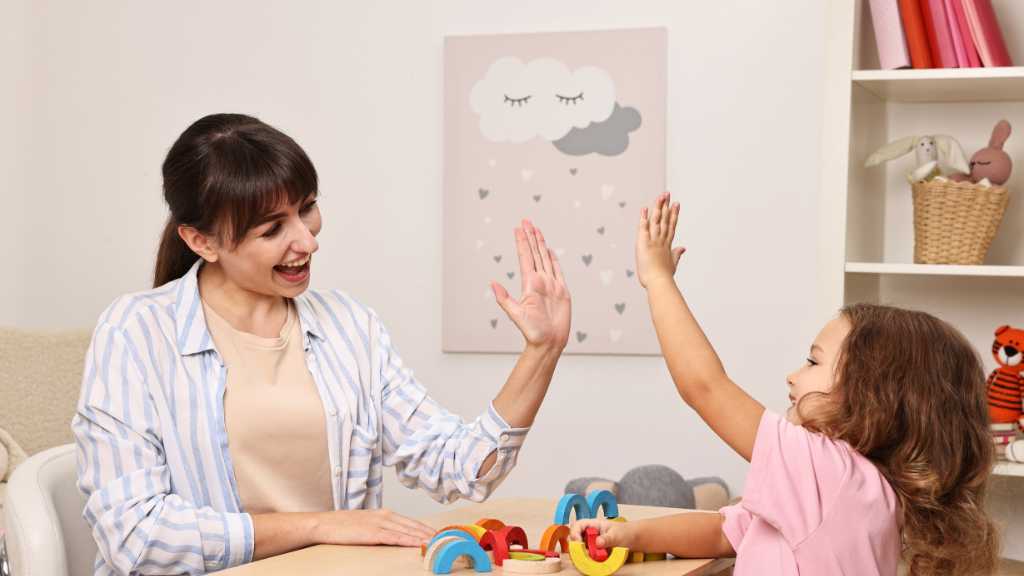 Therapist giving child a high five during autism support activity