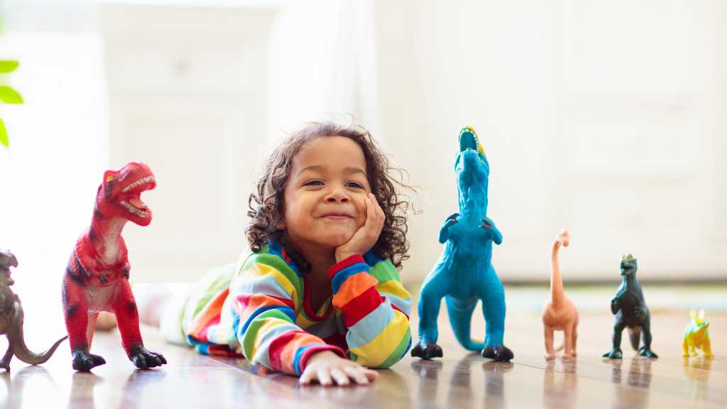 Toddler lining up dinosaur toys, signs of autism in toddlers and repetitive play