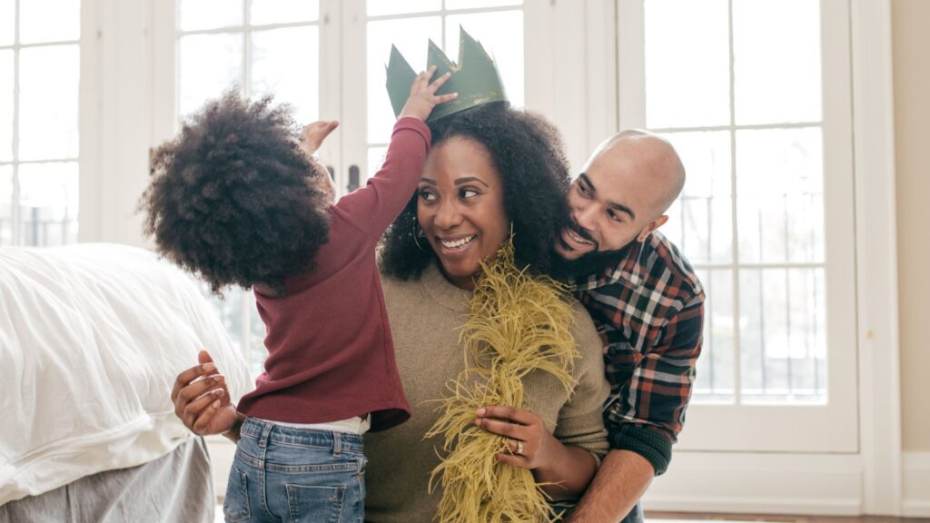 Parents engaging in play with their young child at home