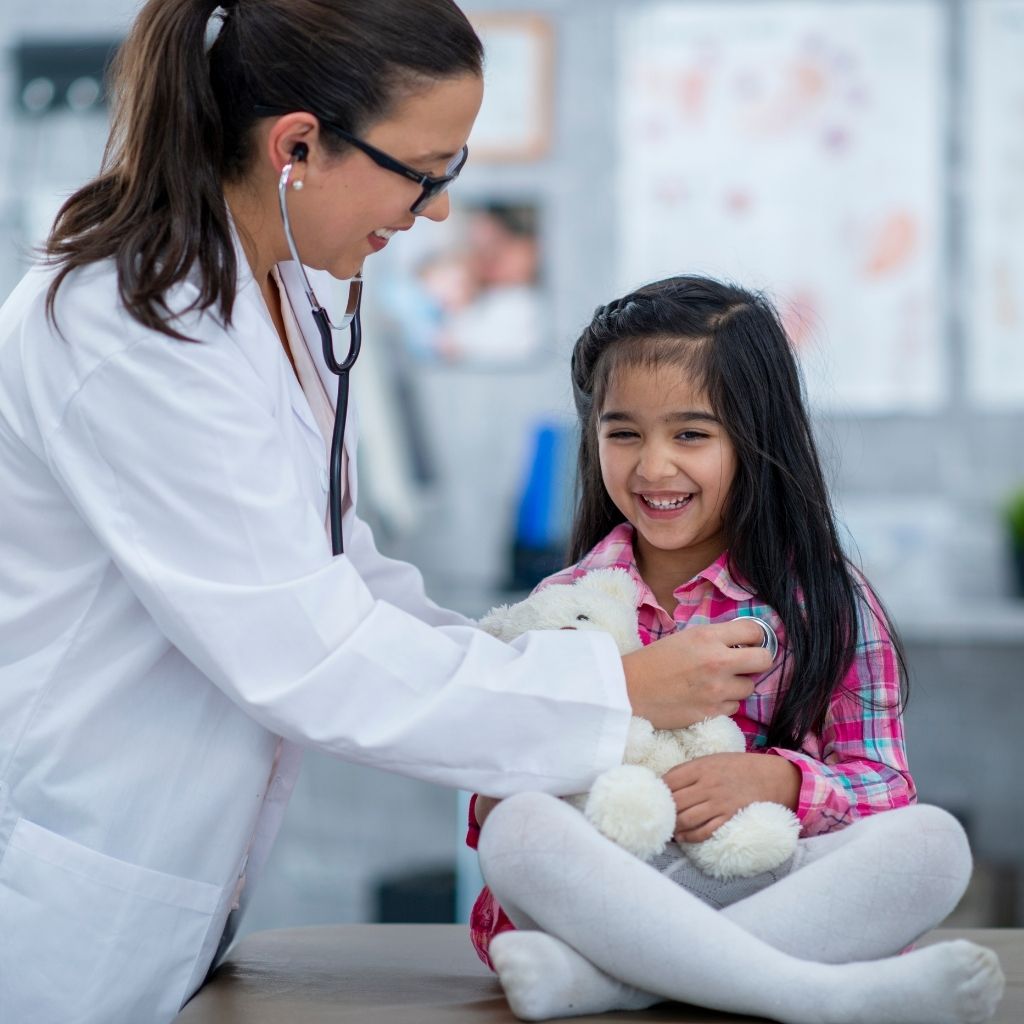Pediatrician examining a young child during a medical appointment