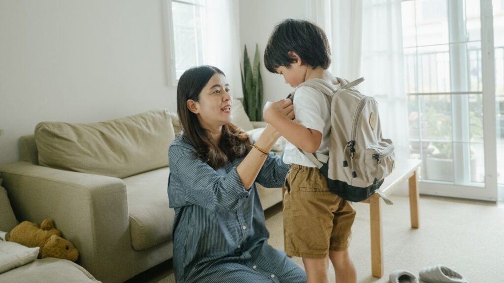 Parent helping preschooler with autism get ready for school