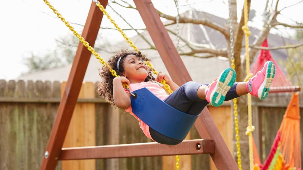 Child enjoying sensory play on a swing while raising a child with autism