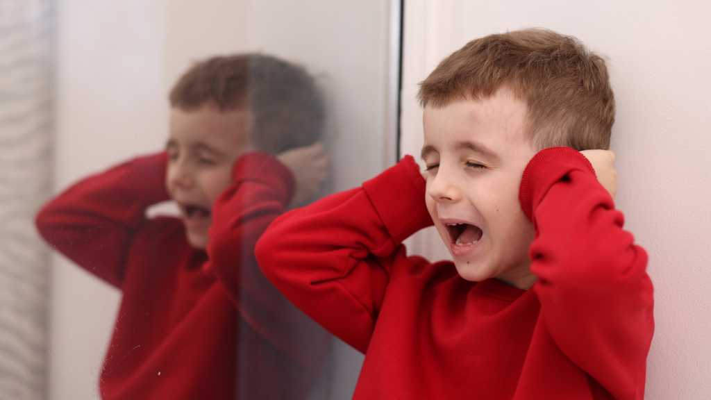 Child covering ears, sensory avoiding behavior and sensory issues in kids
