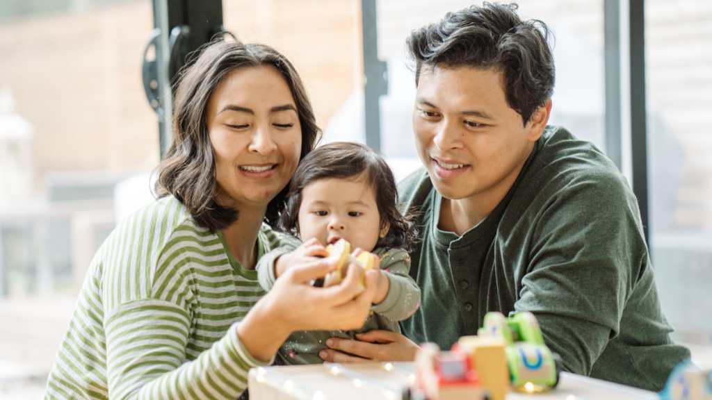 Parents playing with toddler, developmental milestones at 18 months and early autism signs