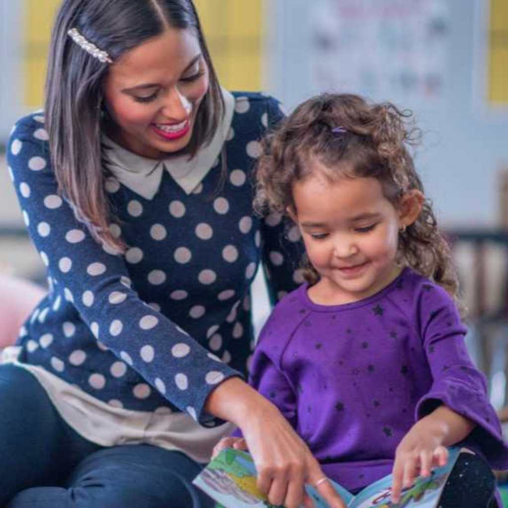Teacher reading with toddler, speech delay or autism and early language skills