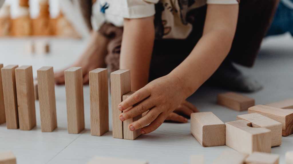 Toddler lining up wooden blocks, repetitive behaviors in toddlers
