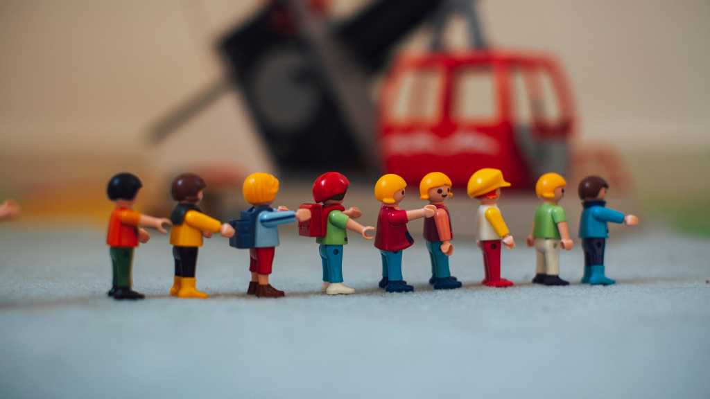 Child lining up toy figures in a row, signs of autism in toddlers