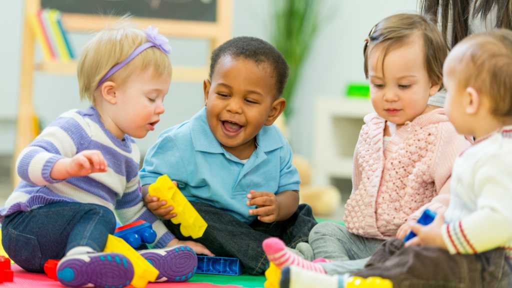 Group of toddlers playing together, developmental milestones at 24 months and social interaction
