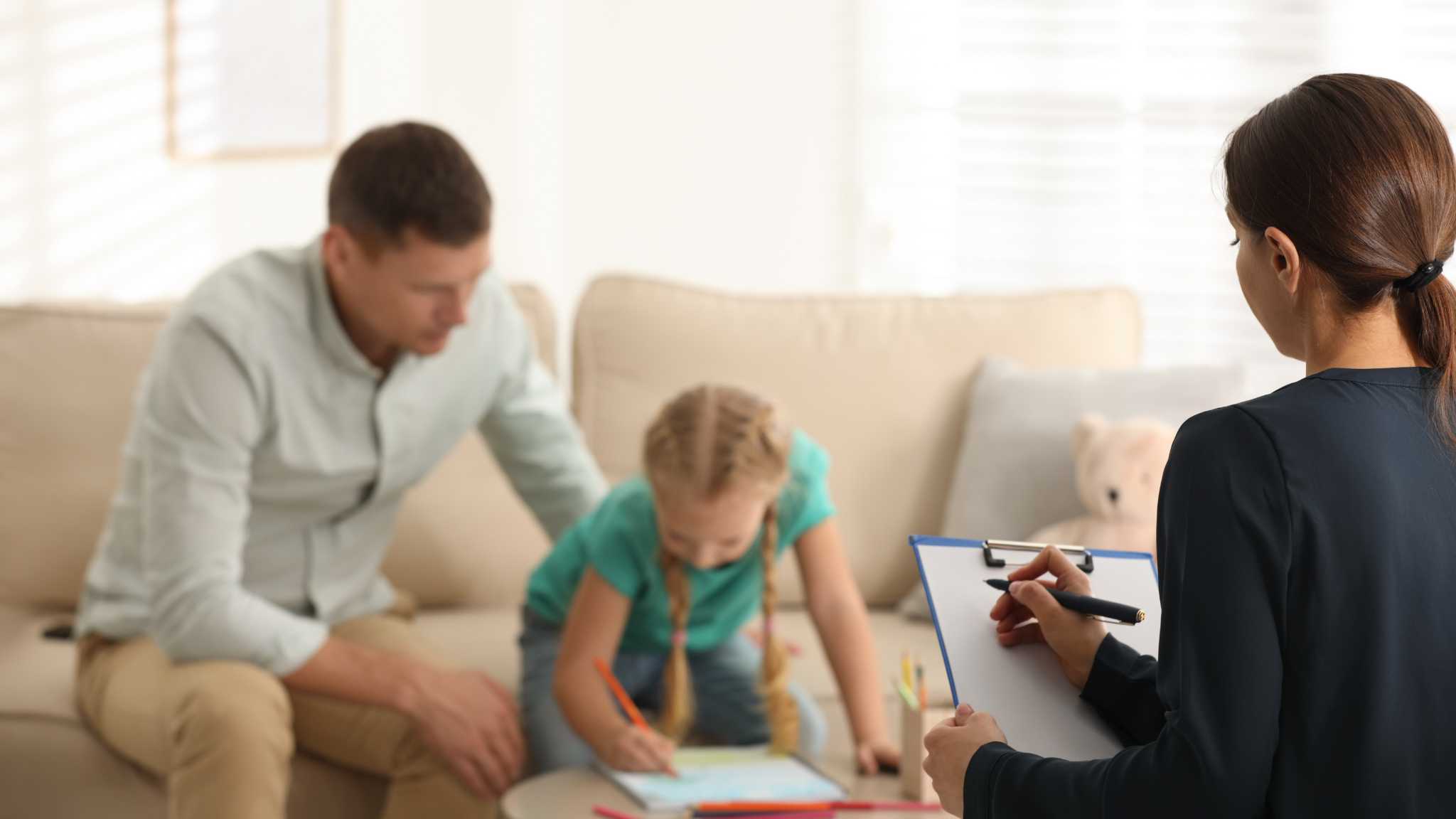 Clinician observing child and parent while reviewing autism evaluation results