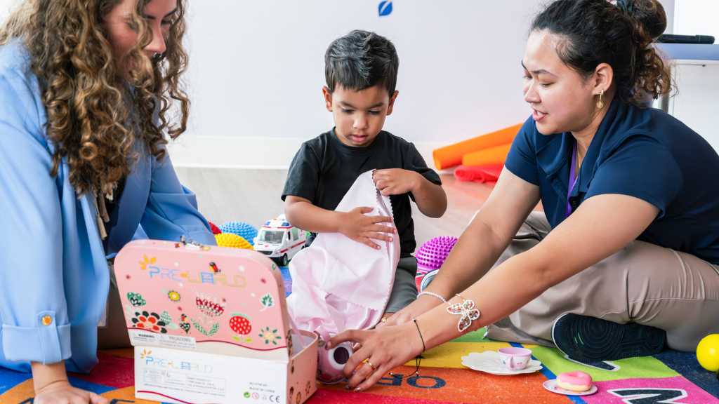 Child and therapists during play-based ABA therapy session