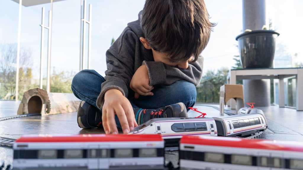 Child deeply focused on toy trains showing autism hyper fixation and special interests